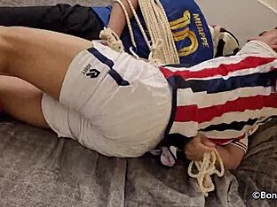 Two gay footballers are tied up and gagged in this BDSM scene.