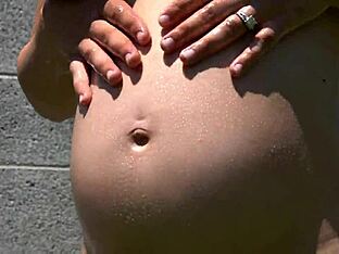 Pregnant man oiled up outdoors