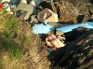 Young lovers caught in steamy public beach rendezvous