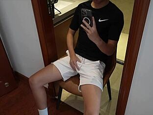 Young gay guy masturbates with a cup
