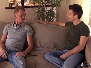 Gay men having sex on the couch while wearing jeans